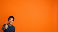 Young African American male wearing dark casual clothing giving thumbs up gesture against vibrant orange background, expressing approval and positivity for advertising and promotional campaigns.
