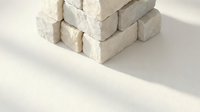 Stack of white chalk pieces arranged on clean surface with soft shadows for educational and artistic projects.