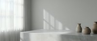 Minimalist concrete countertop with ceramic vases and natural window light casting geometric shadows on neutral wall for modern interior design projects.