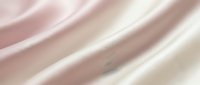 Smooth silk fabric with soft waves in neutral tones of blush pink, taupe, and cream, creating an elegant flowing texture suitable for luxury backgrounds and design projects.