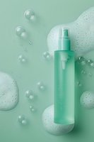 Cosmetic spray bottle with foam and bubbles on mint green background. Clean skincare product packaging mockup for beauty and personal care advertising.