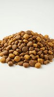 Pile of brown dry pet food kibble isolated on white background for animal nutrition and feeding concepts.