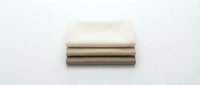 Folded neutral fabric swatches in cream and taupe tones stacked together on white background, suitable for textile design, interior decoration, and material selection projects.