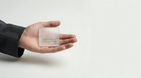 Male hand in dark business sleeve holding white embossed square business card mockup on neutral background for branding and corporate identity design projects.