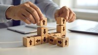 Business professional arranging wooden blocks with directional arrows symbolizing strategic planning, decision making and organizational management concepts.
