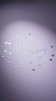 Happy Birthday text in silver script on soft purple background with scattered metallic star confetti, elegant greeting card design.