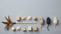 Minimalist flat lay composition with natural wooden geometric shapes, feathers and decorative mice on neutral background for creative projects.
