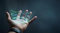 Caucasian male hand holding glowing digital holographic interface with green and blue light effects against dark background for technology and innovation concepts.