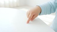 Child's hand pointing at blank white surface, isolated on light background, ready for design mockups, educational materials, and marketing campaigns.