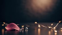 Festive Christmas ornament with warm golden string lights creating cozy holiday atmosphere on dark wooden surface for seasonal decorating projects.