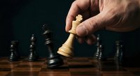 Strategic chess move with hand positioning white king piece on wooden board against dark background for business and leadership concepts.