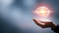 Human hand holding glowing brain with sound waves representing artificial intelligence, neuroscience, mental health and cognitive technology concepts.