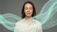 Young Caucasian woman with closed eyes in white shirt surrounded by flowing green energy waves on gray background for wellness and meditation concepts.