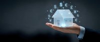 Real estate investment concept with businessman hand holding glowing house model and floating currency symbols for financial planning presentations.