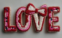 Embroidered love text patch with pink and red thread stitching on fabric background for romantic crafts and apparel decoration projects.