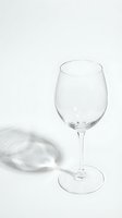 Empty clear wine glass on white background with elegant shadow, minimalist style for restaurant, bar, and beverage design concepts.