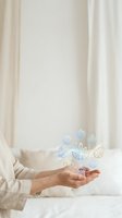 Woman hands holding floating eco-friendly icons representing sustainability, green technology and environmental conservation in bright interior.
