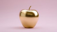 Luxurious golden apple on soft pink background, symbolizing wealth, success, and premium quality for business concepts and luxury branding.