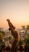 Woman in beige ribbed crop top and matching shorts stretching arms upward on urban rooftop terrace at sunset, surrounded by potted plants, cityscape and bokeh lights in background.