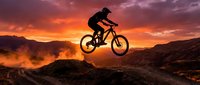 Mountain biker jumping at sunset with dramatic orange and purple sky. Extreme sports adventure and outdoor recreation concept for active lifestyle content.