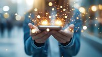 Magical glowing sparkles and light emerging from smartphone held in hands against blurred city background with bokeh lights. Digital transformation concept.