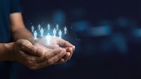 Cupped hands holding glowing human figures representing teamwork, leadership and community connection in digital business environment.