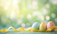 Pastel colored Easter eggs decorated with dots and yellow ribbon on blurred spring bokeh background with soft sunlight and copy space.