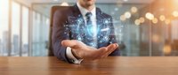 Businessman in formal suit displaying digital network hologram above palm, representing technology innovation and business connectivity in modern office environment.