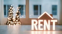 Illuminated rent sign with glowing Christmas lights in background creating bokeh effect, modern minimalist real estate concept for rental property market.