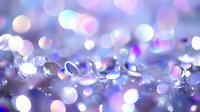 Macro shot of sparkling crystal beads and water droplets with soft bokeh lights in purple, pink, and white tones, suitable for luxury, celebration, and festive backgrounds.