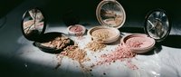 Professional makeup cosmetics collection with scattered powder blush and eyeshadow compacts in neutral tones for beauty and fashion industry.