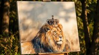 Majestic lion wearing ornate crown portrait painting displayed on easel outdoors with natural lighting and foliage shadows creating artistic presentation.