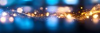 Abstract glowing golden sparkles and light bokeh effect on dark blue background with magical shimmering particles flowing in motion.