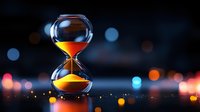 Hourglass with flowing sand against dark background with colorful bokeh lights creating atmospheric mood. Time concept with copy space.