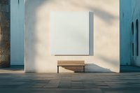 Minimalist architectural composition with wooden bench against white wall, blank canvas frame above, and dramatic natural shadow play creating geometric patterns.