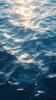 Gentle ocean waves reflecting golden sunlight, creating a serene blue water surface with sparkling highlights for nature backgrounds.