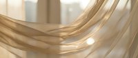 Flowing golden silk fabric with soft light creating elegant waves and curves in warm beige tones for luxury textile and fashion design projects.