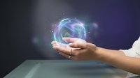 Hand holding glowing digital sphere with holographic data visualization and light effects against dark background for technology concepts.