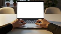 Modern workspace with hands typing on laptop computer with blank white screen for mockup, perfect for presentations and digital content display.