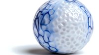 White golf ball with blue marble pattern design on textured dimpled surface against soft white background, isolated sports equipment macro photography.