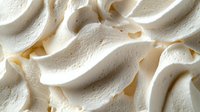 Creamy white meringue peaks with soft swirls and delicate texture create an elegant dessert background pattern, showcasing light and shadow details.