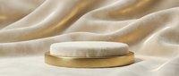 Luxury gold and marble round podium on soft beige draped fabric, elegant product display stand for cosmetics and premium brand presentation.