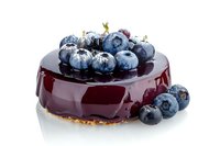Glossy blueberry mousse cake topped with fresh berries and mirror glaze, isolated on white background for bakery and dessert design.