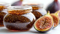 Homemade fig jam in glass jars with fresh figs, showcasing preserved fruit spread for cooking, baking, and gourmet food styling projects.