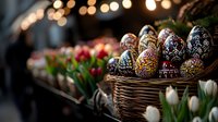 Decorated Easter eggs with intricate folk patterns in wicker basket alongside fresh spring tulips, creating festive holiday atmosphere with soft bokeh lights.