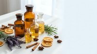 Essential oils in amber bottles with dried citrus, lavender, cinnamon and star anise for natural aromatherapy and wellness treatments.
