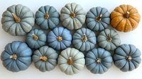 Decorative pumpkins in muted blue and gray tones with one orange accent arranged in rows on white background, creating modern farmhouse autumn decor.