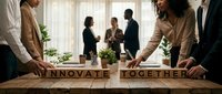 Diverse business team collaborating around a wooden table with letter blocks spelling Innovate Together, symbolizing teamwork and corporate innovation.