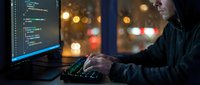 Young male programmer coding at night with city lights background, software development and technology workspace for web design projects.