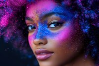Young African American woman with creative neon pink and blue glitter makeup art on dark background, showcasing vibrant cosmetic fantasy design and natural curly hair.